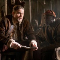 Photo Chris Raphael - Actors in costume sit in a dimly lit barn